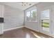 Dining area with light wood accent wall, modern lighting, and access to the backyard at 8335 Village Pl, Suwanee, GA 30024