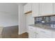 Kitchen with sleek subway tile backsplash, granite countertops, and white cabinets at 8335 Village Pl, Suwanee, GA 30024