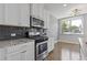 Modern kitchen featuring stainless steel appliances, granite countertops, and subway tile backsplash at 8335 Village Pl, Suwanee, GA 30024