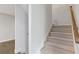 Neutral stairway featuring carpeted steps, wood handrail and a light grey paint at 8335 Village Pl, Suwanee, GA 30024