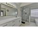 Bright bathroom featuring dual vanity, large mirror, shower with bench, and soaking tub at 2822 Savannah Walk Cv, Suwanee, GA 30024