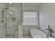 Bathroom highlighting the shower with bench, soaking tub, and natural light at 2822 Savannah Walk Cv, Suwanee, GA 30024