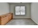 Empty bedroom with hardwood floors, window, and a wooden dresser at 2822 Savannah Walk Cv, Suwanee, GA 30024