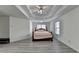 Bedroom boasts gray wood floors, decorative ceiling, fan, and windows at 2822 Savannah Walk Cv, Suwanee, GA 30024