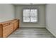 Empty bedroom with hardwood floors, window, and a wooden dresser at 2822 Savannah Walk Cv, Suwanee, GA 30024