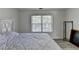 Bright bedroom featuring hardwood floors, a large window, and a white bed frame at 2822 Savannah Walk Cv, Suwanee, GA 30024