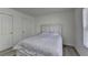 Bright bedroom featuring hardwood floors, a large window, and a white bed frame at 2822 Savannah Walk Cv, Suwanee, GA 30024