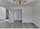 Spacious dining room with modern flooring, wainscoting, and an elegant chandelier at 2822 Savannah Walk Cv, Suwanee, GA 30024
