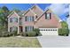 Charming two-story brick home featuring manicured landscaping and a two-car garage at 2822 Savannah Walk Cv, Suwanee, GA 30024