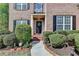 Inviting front entrance with a black door framed by manicured shrubs at 2822 Savannah Walk Cv, Suwanee, GA 30024