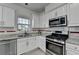 Bright kitchen features granite counters, white cabinets, and stainless steel appliances at 2822 Savannah Walk Cv, Suwanee, GA 30024