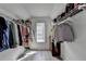 Walk-in closet has built-in shelving, hanging rods, and a small window for natural light at 2822 Savannah Walk Cv, Suwanee, GA 30024