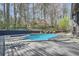 Backyard pool with diving board surrounded by wooden deck and mature trees at 3011 Cravey Trl, Tucker, GA 30345