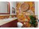 Stylish powder room with granite sink, artistic tiled walls, a plant, and modern fixtures at 3085 Balearic Se Dr, Marietta, GA 30067