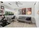 Office area with a Peloton bike, work desk, gray sofa, and natural light from a window at 3085 Balearic Se Dr, Marietta, GA 30067