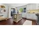 Bright eat-in kitchen featuring a kitchen island, stainless steel appliances, dark wood floors, and large windows at 3085 Balearic Se Dr, Marietta, GA 30067