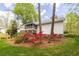 Backyard featuring a screened deck, beautiful flower beds with vibrant azaleas, and well-manicured lawn at 1800 East Gate Dr, Smoke Rise, GA 30087