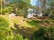 Picturesque backyard featuring a gentle slope, lush greenery, mature trees, and a glimpse of the home's balcony at 1800 East Gate Dr, Smoke Rise, GA 30087