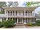 Charming two-story home with a welcoming front porch and beautifully manicured landscaping at 1800 East Gate Dr, Smoke Rise, GA 30087
