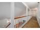 Hallway with neutral carpet, wainscoting, wood railing and trimmed doorways leading to various rooms at 1800 East Gate Dr, Smoke Rise, GA 30087