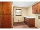 Charming laundry room with brick floors, classic wallpaper, wooden cabinets, and natural light from the window at 1800 East Gate Dr, Smoke Rise, GA 30087