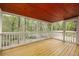 Open porch with wood floors, white railings, and view of the surrounding greenery at 1800 East Gate Dr, Smoke Rise, GA 30087