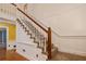 A beautiful carpeted staircase features white banisters and wood trim, adding a touch of elegance to the home's interior at 1800 East Gate Dr, Smoke Rise, GA 30087