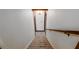Carpeted staircase with a wooden handrail leading downwards creating an inviting and safe transition at 1800 East Gate Dr, Smoke Rise, GA 30087
