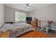 Bedroom features a ceiling fan, hardwood floors, and a window at 4819 Elam Rd, Stone Mountain, GA 30083