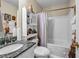 Cozy bathroom featuring a shower-tub combo, granite-topped vanity, and decorative shelving at 510 Ashland Manor Dr, Lawrenceville, GA 30045