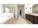Bright bathroom with a separate shower, tub, walk-in closet, and double sink vanity at 715 Laura Jean Ct, Buford, GA 30518