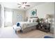 Cozy bedroom featuring carpeted floors, a ceiling fan, and large picture window at 715 Laura Jean Ct, Buford, GA 30518