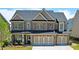 Beautiful two-story home features brick accents, manicured lawn and a three-car garage at 715 Laura Jean Ct, Buford, GA 30518