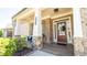 Inviting front porch with brick columns, a decorative wreath, and cozy seating area at 715 Laura Jean Ct, Buford, GA 30518