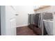 This laundry room features a modern washer and dryer, wood-look flooring, and convenient shelving for storage at 715 Laura Jean Ct, Buford, GA 30518
