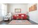 Bright living room features a red sofa, decorative rug, and modern decor at 715 Laura Jean Ct, Buford, GA 30518
