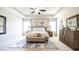 Spacious main bedroom with tray ceiling, ceiling fan, neutral tones and plenty of light at 715 Laura Jean Ct, Buford, GA 30518