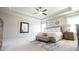 Spacious main bedroom with a tray ceiling, neutral carpet, and stylish furnishings at 715 Laura Jean Ct, Buford, GA 30518