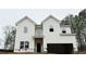 Exterior of new two-story home with white vinyl siding and a two-car garage awaiting finishing touches at 120 Cedar Cliff Ct, Temple, GA 30179