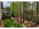 A serene backyard features mature trees and landscaping, with other homes visible at 325 N Saint Phillip Ln, Alpharetta, GA 30022