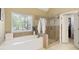 Bathroom showcasing a soaking tub, walk-in shower, and large window with natural light at 325 N Saint Phillip Ln, Alpharetta, GA 30022