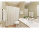 Clean bathroom features a shower with a white curtain, a sink with a large mirror, and tile flooring at 325 N Saint Phillip Ln, Alpharetta, GA 30022