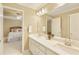 Bathroom with dual sink vanity, white cabinets, quartz countertops, and a view to the bedroom at 325 N Saint Phillip Ln, Alpharetta, GA 30022