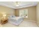 Cozy bedroom featuring a large window, tray ceiling, and soft, neutral decor at 325 N Saint Phillip Ln, Alpharetta, GA 30022