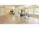 Open concept bonus room with wood-look floors, including a living area and workout equipment at 325 N Saint Phillip Ln, Alpharetta, GA 30022