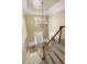 Elevated foyer view showing a staircase, front door, elegant chandelier, and hardwood floors at 325 N Saint Phillip Ln, Alpharetta, GA 30022