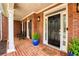 Cozy front porch with brick flooring, white columns, and potted plants framing the entrance at 325 N Saint Phillip Ln, Alpharetta, GA 30022