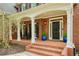 Welcoming front porch with classic brick flooring, white columns, and a black front door at 325 N Saint Phillip Ln, Alpharetta, GA 30022