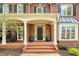 Inviting front porch with brick steps, columns, and decorative plants, creating a welcoming entrance at 325 N Saint Phillip Ln, Alpharetta, GA 30022