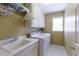 Laundry room with sink, washer, dryer, white cabinets, and ample storage space at 325 N Saint Phillip Ln, Alpharetta, GA 30022
